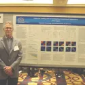 Dr. Clapper in front of Poster