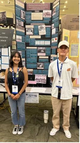 2 students stand in front of their display
